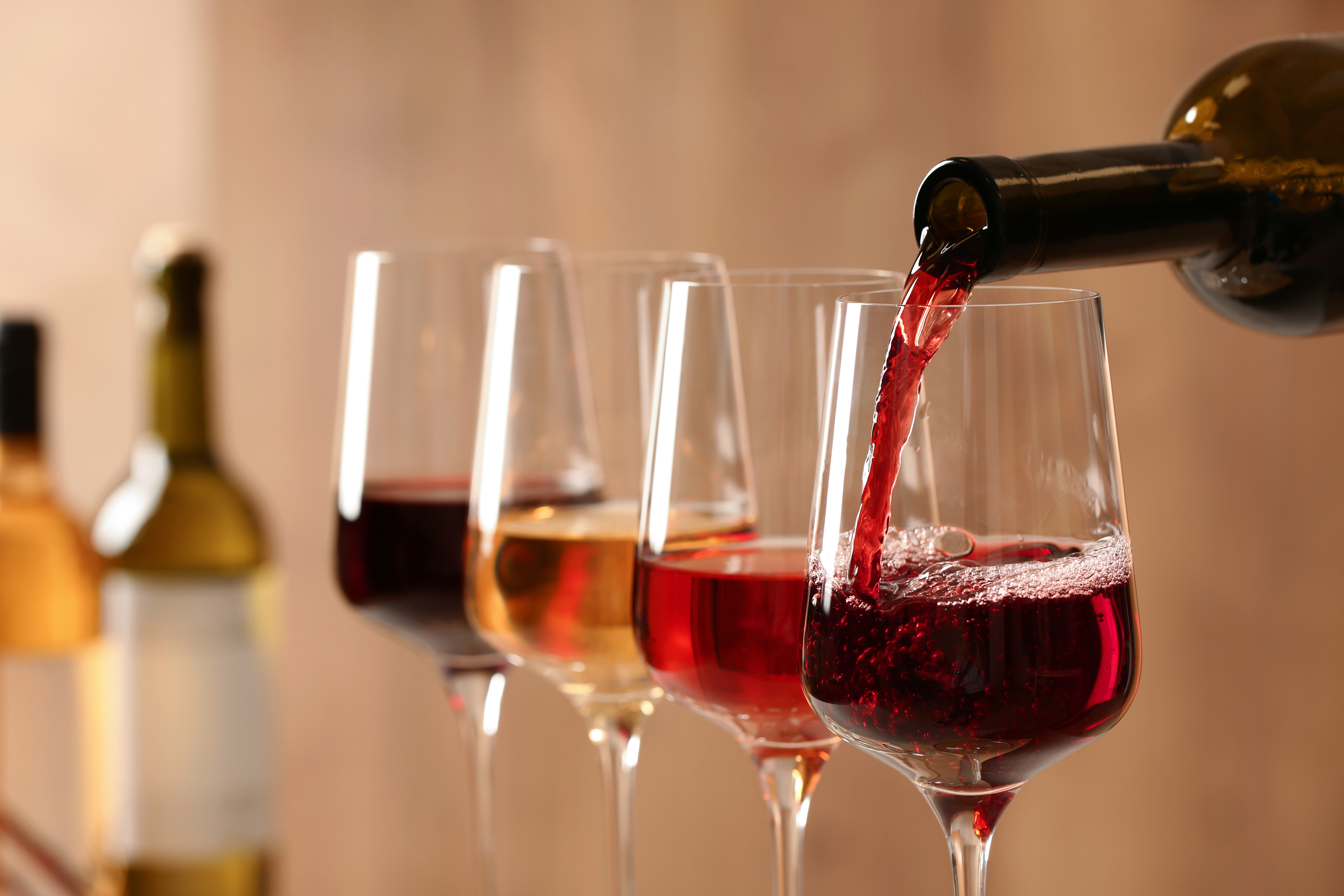 Wein wird aus Flasche in Gläser gegossen, Hintergrund blurry