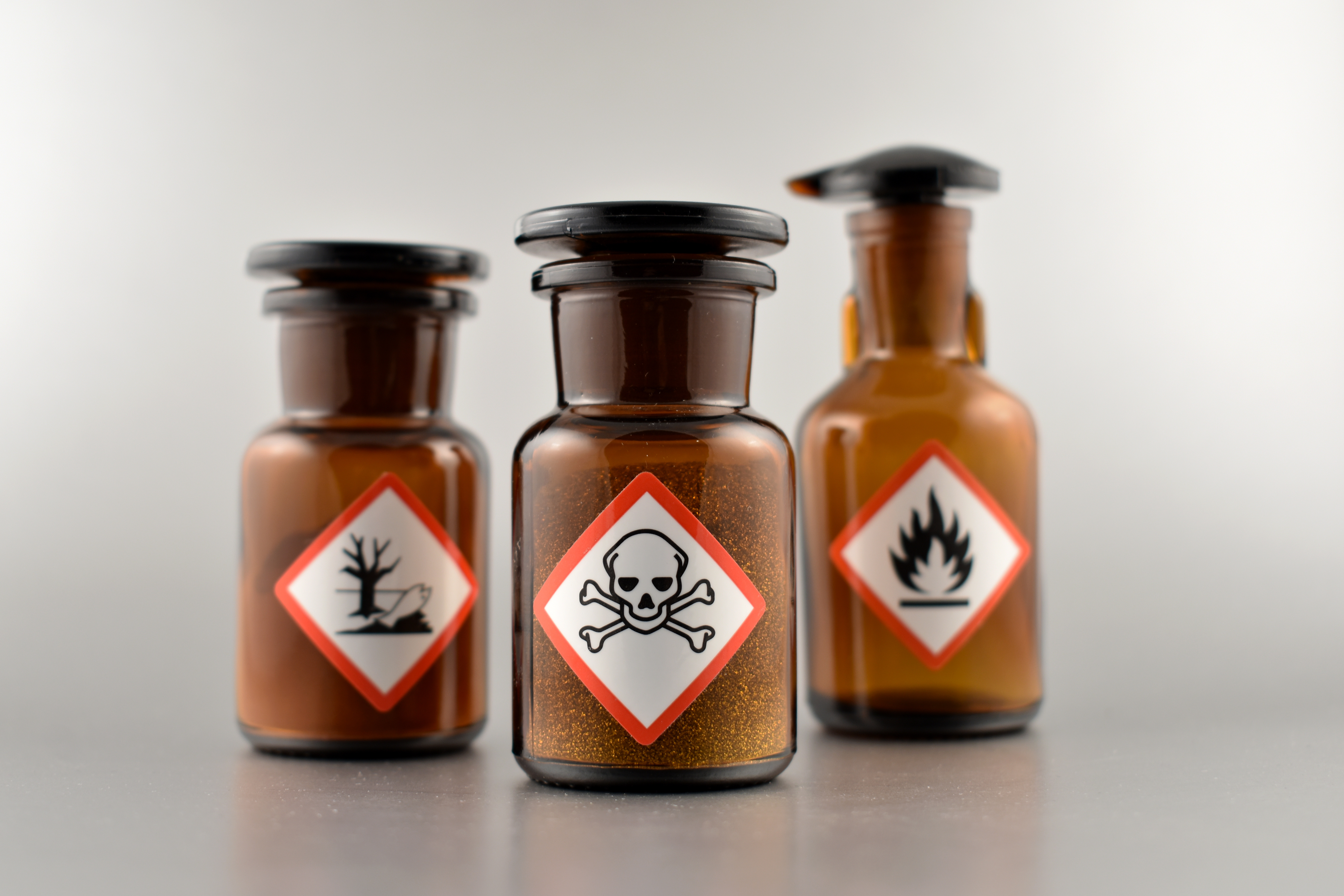 Braune Laborglasbehälter mit Gefahrstoffkennzeichnung 