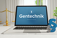 Aufgeklappter Laptop mit dem Schriftzug "Gentechnik" auf dem Bildschirm.