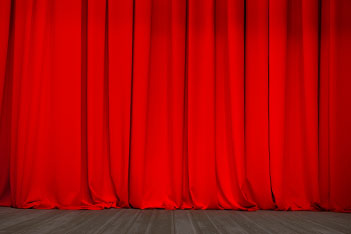 Bühne mit geschlossenem rotem Samtvorhang.